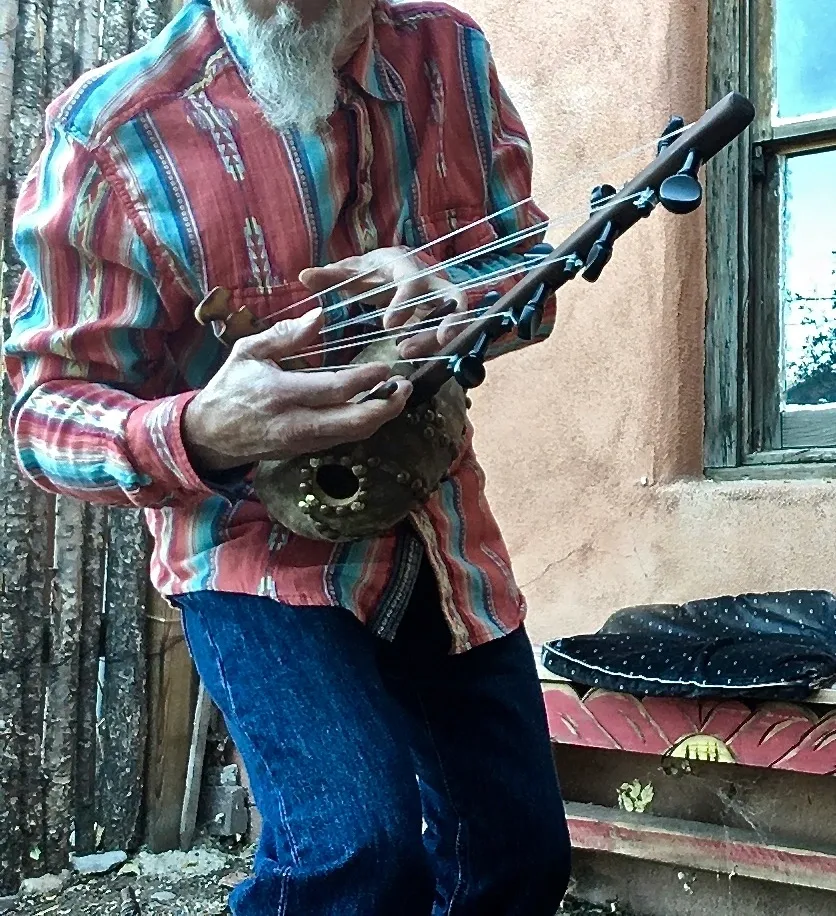 An old man playing a Ngoma in front of a house, creating beautiful African music.