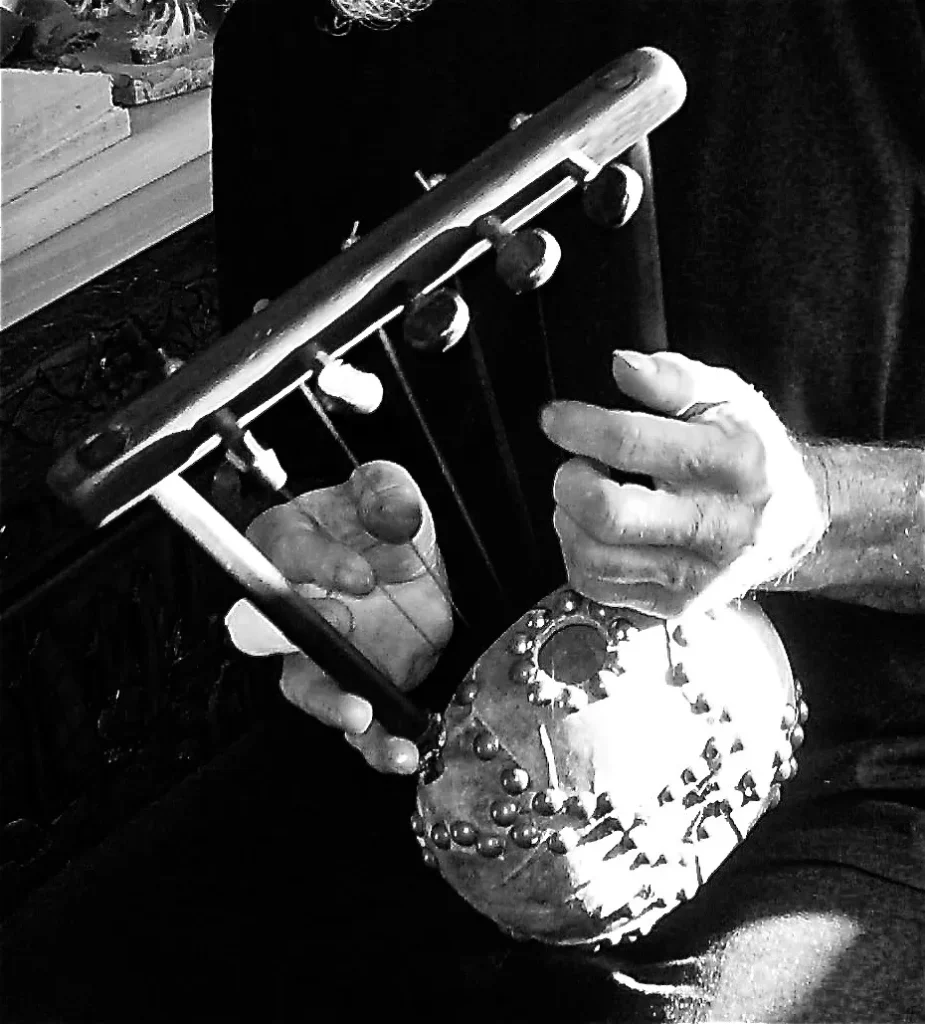 A black and white photo of a man playing a Kalimba.