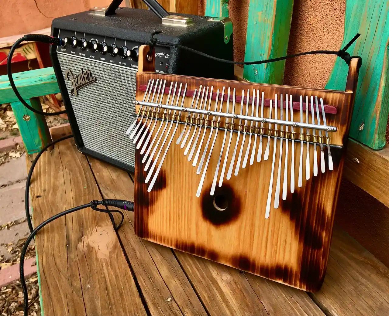 A wooden ukulele is sitting on a wooden bench.