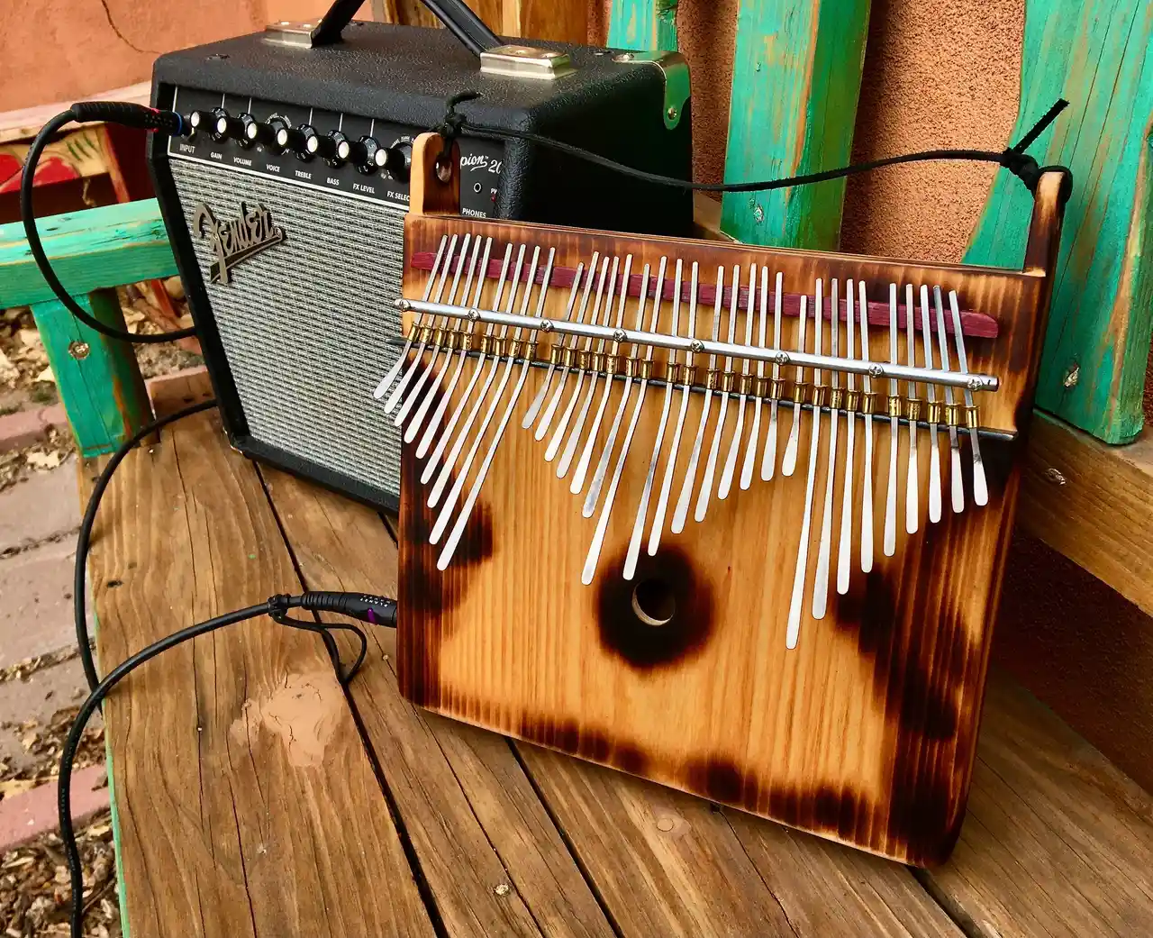 A wooden ukulele, a type of gourd instrument, is sitting on a wooden bench.