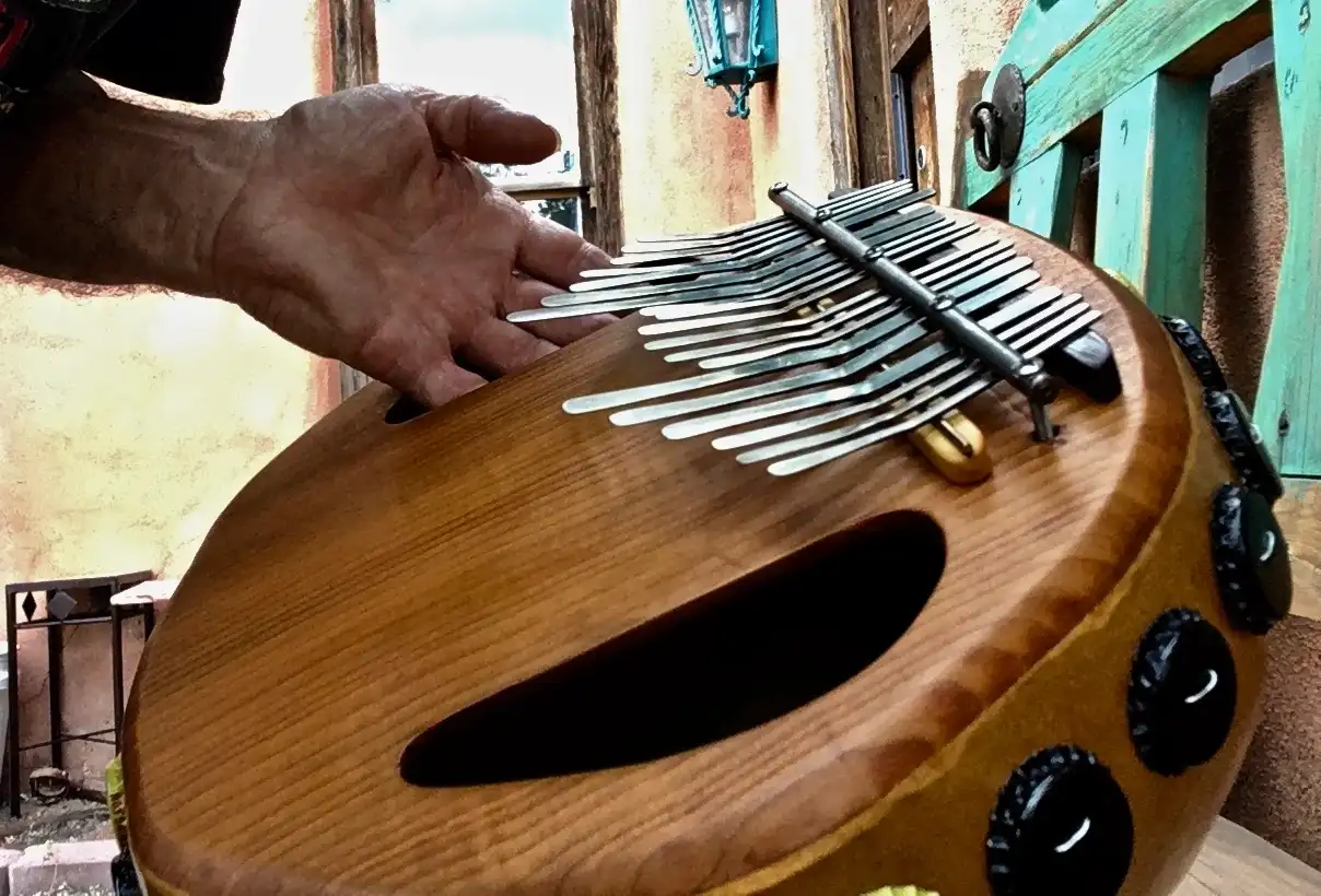 A person is playing an African harp called the ilimba.