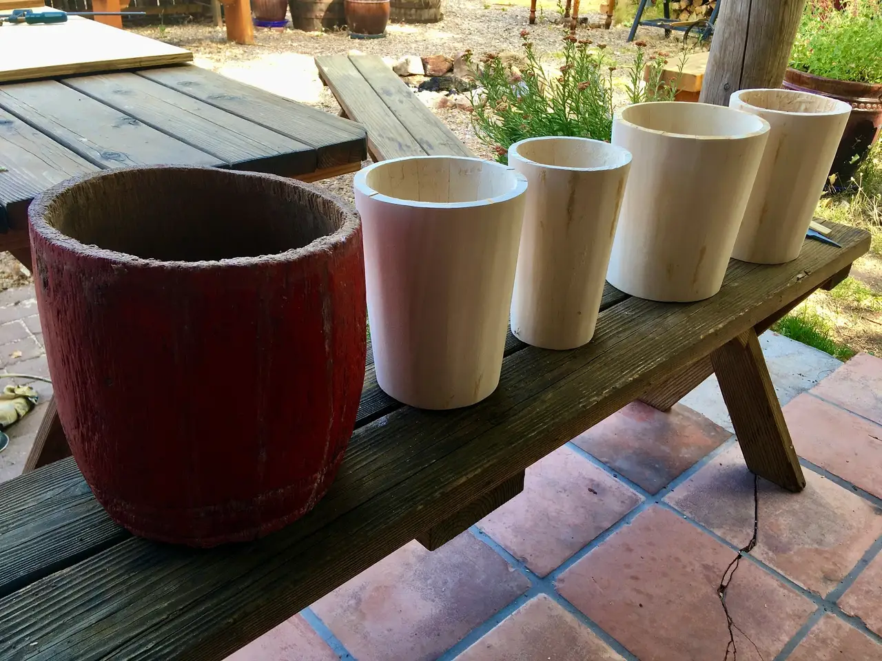 Four Ilimba pots on a wooden bench.