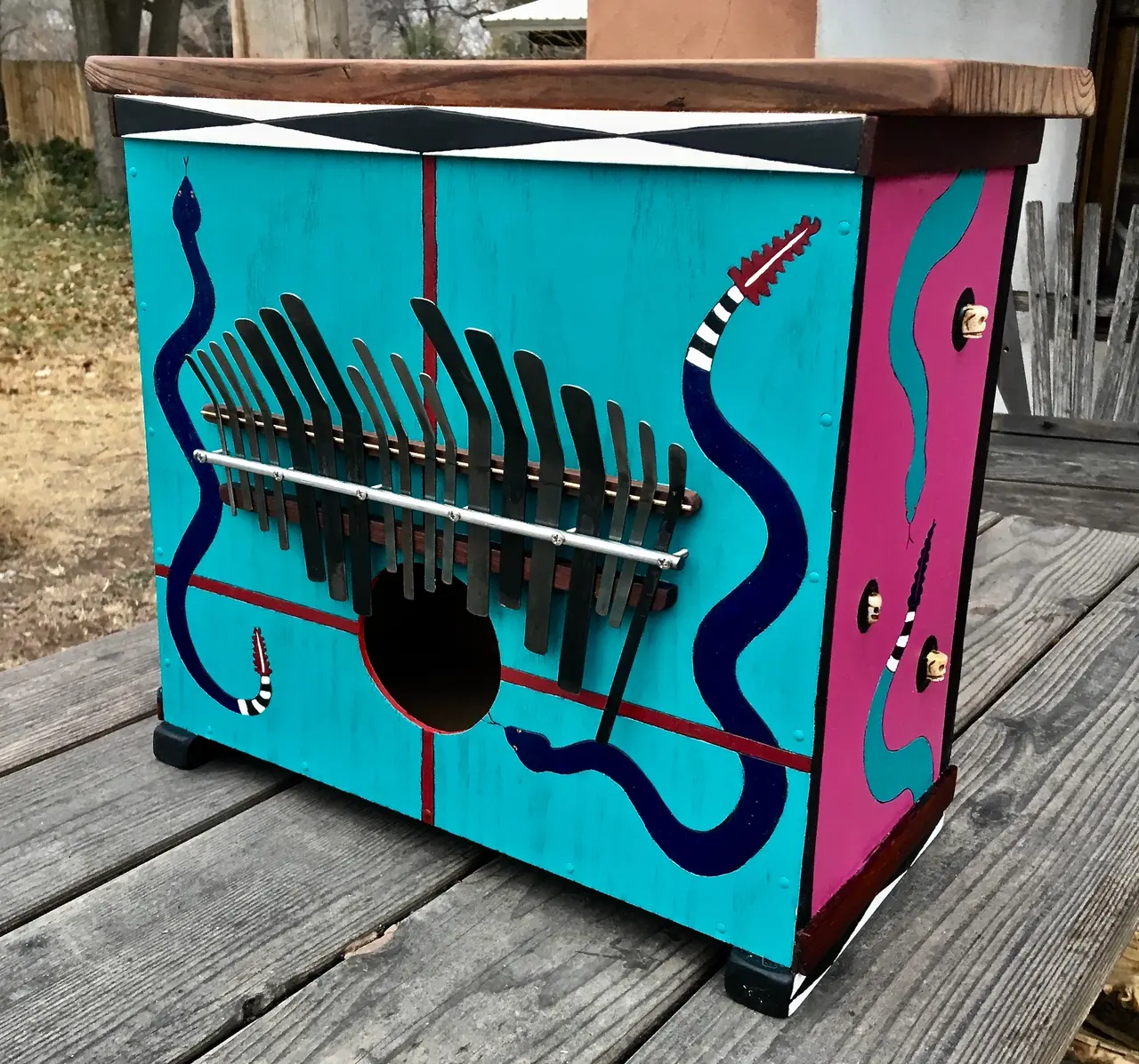 A colorful wooden box with a snake painted on it - perfect for storing your Kalimba.