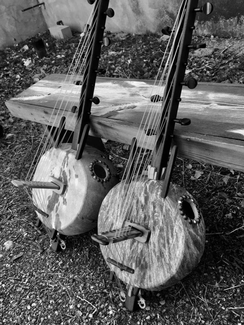 Two banjos, traditionally used in African music, sitting on a wooden bench.