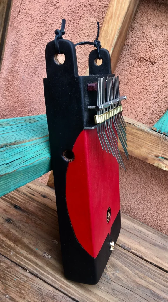 A red and black Ngoma sitting on a wooden bench.