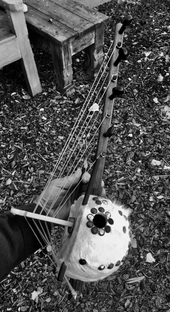 A black and white photo of a person holding a harp, showcasing the intricate beauty of Ngoma music.