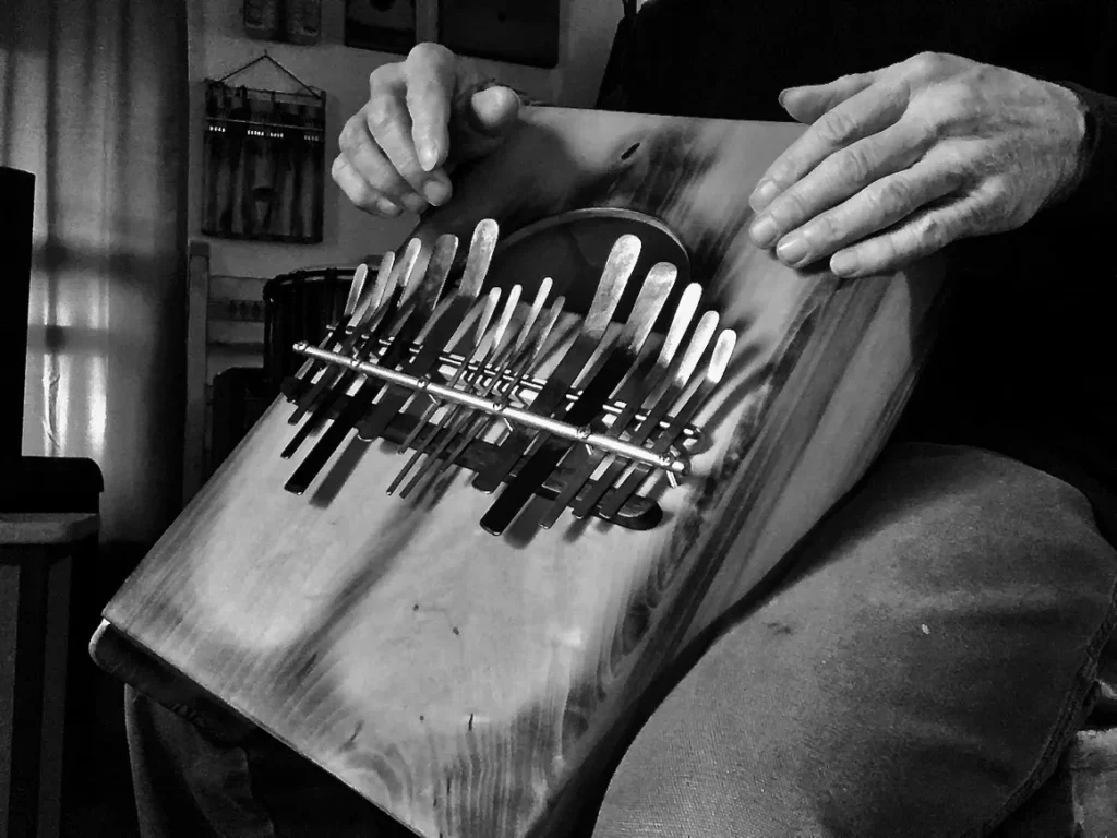 A man holding a Kalimba, a wooden instrument.