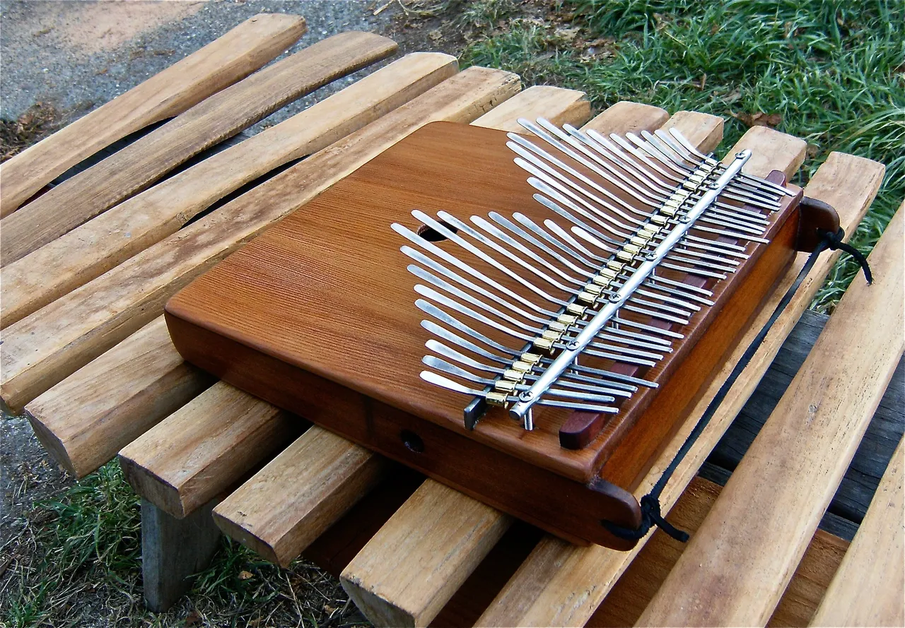 A Kongoma instrument sitting on top of a wooden bench.