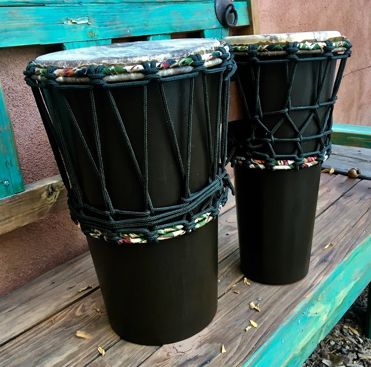 Two djembe drums, African harps, and Ilimba sitting on a bench.