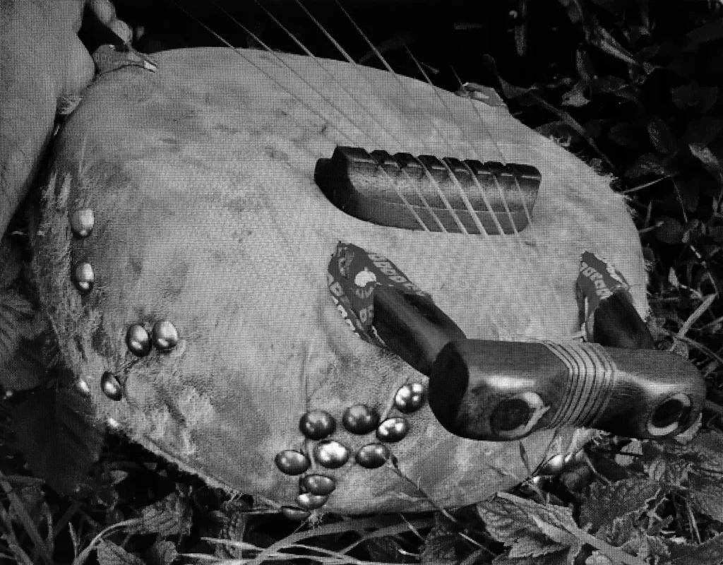 A black and white photo of a man holding a musical instrument, possibly a Kalimba.