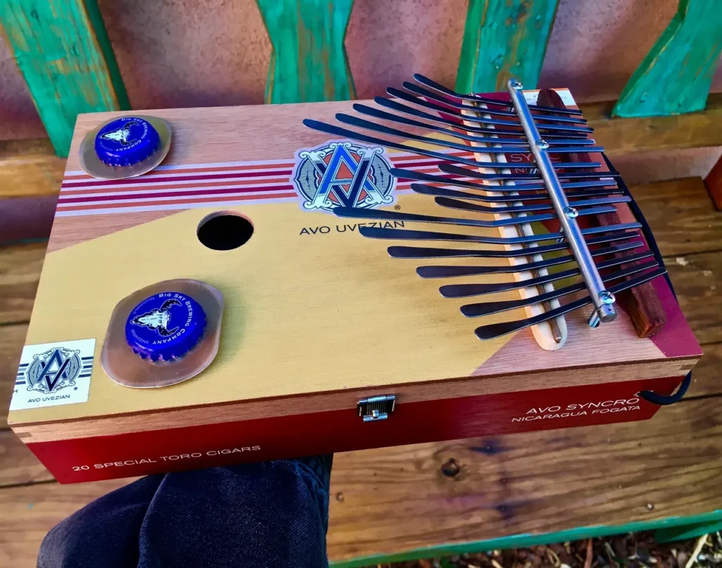 A person is holding an Ngoma in front of a wooden box, creating captivating African music.