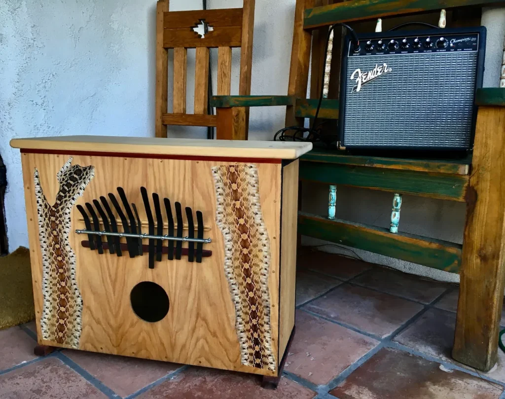 A wooden box with a guitar sitting on a porch.