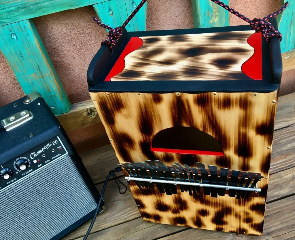 A wooden box with a guitar sitting on a wooden deck.