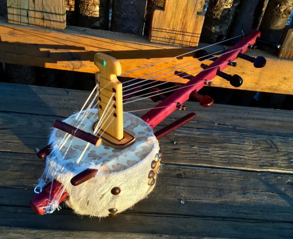 An Ngoma, a wooden instrument used in African music, is sitting on a wooden table.