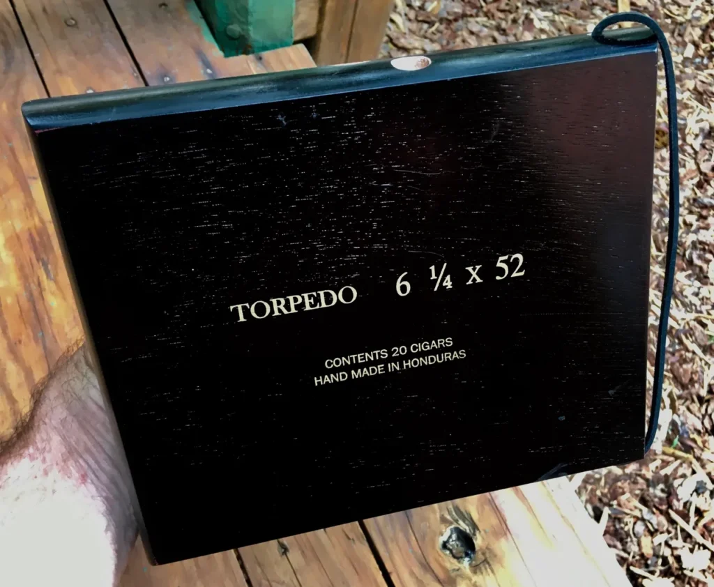 A person is holding a black box with the words torbodo 6 6 s that contains Ngoma, an African music instrument.