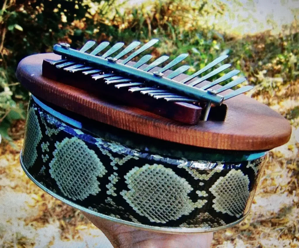 An individual playing a Ngoma, an African musical instrument made from python skin.