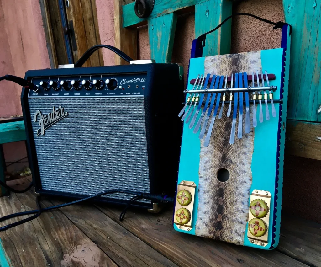 A blue acoustic guitar and a blue electric guitar on a wooden bench.