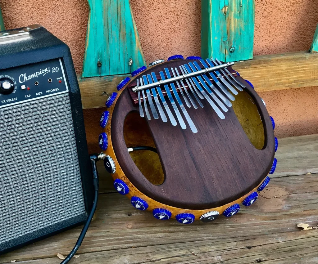 An Ilimba, an African harp, is sitting on a wooden bench.