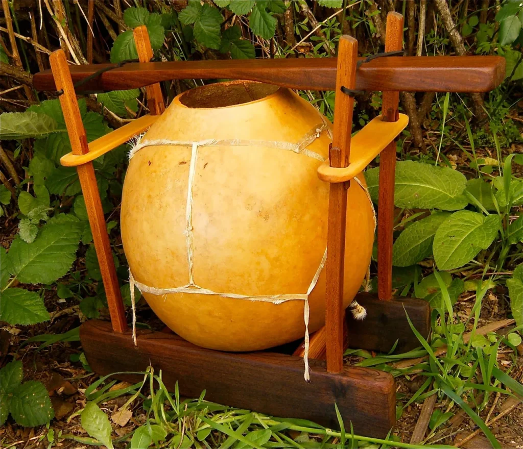 A large wooden pot with a wooden handle, perfect for creating melodic tunes when transformed into a gourd instrument.