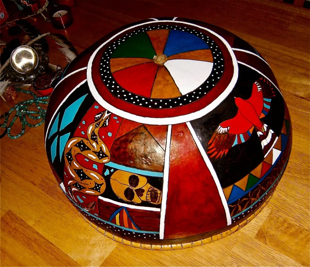 A red, white, and blue bowl on a wooden table inspired by Ngoma, African music.