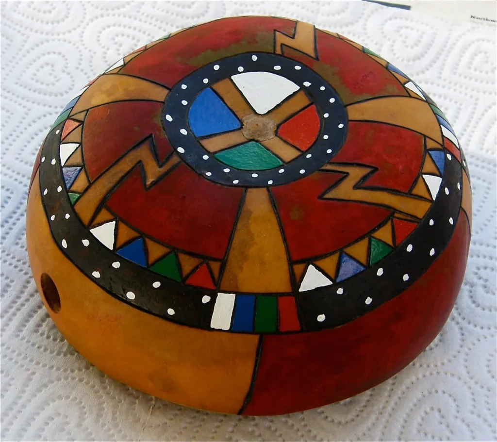 A wooden bowl with a colorful Ngoma design