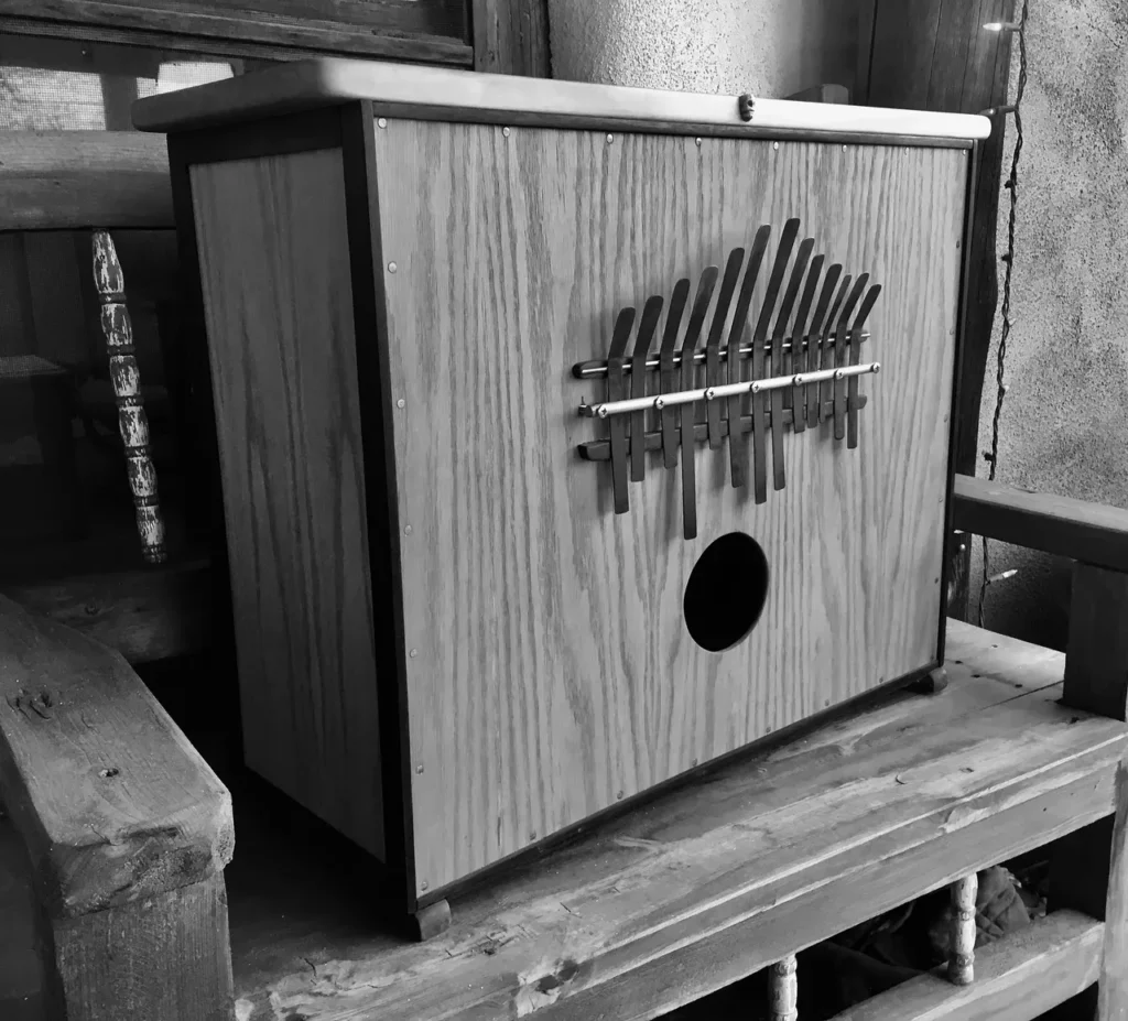 A black and white photo of a wooden box, resembling a Kalimba or African drum.