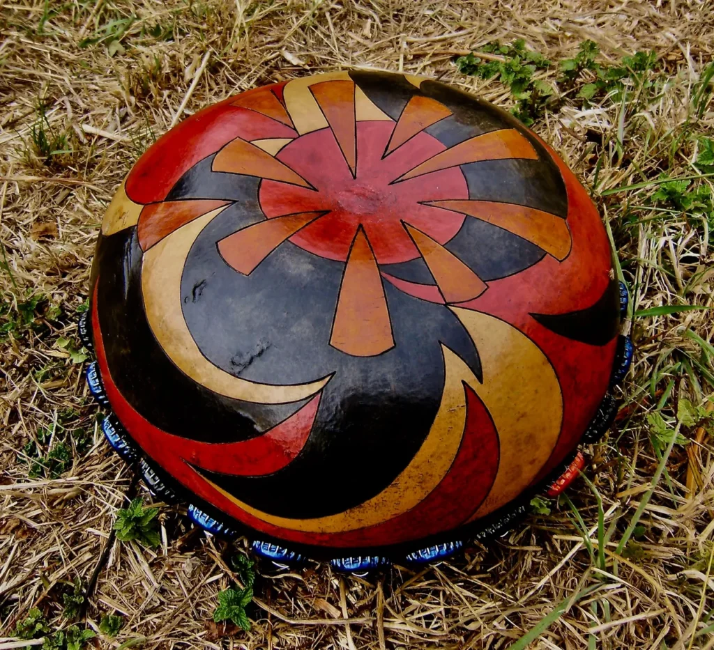 An Ilimba painted ball sitting in the grass.