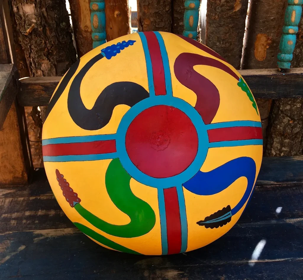 A vibrant Ngoma drum sitting on a wooden bench.