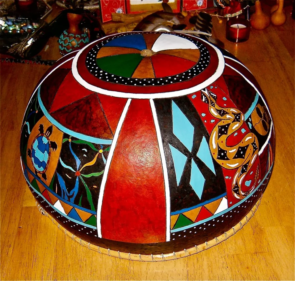 An Ngoma-inspired painted bowl on a wooden table.