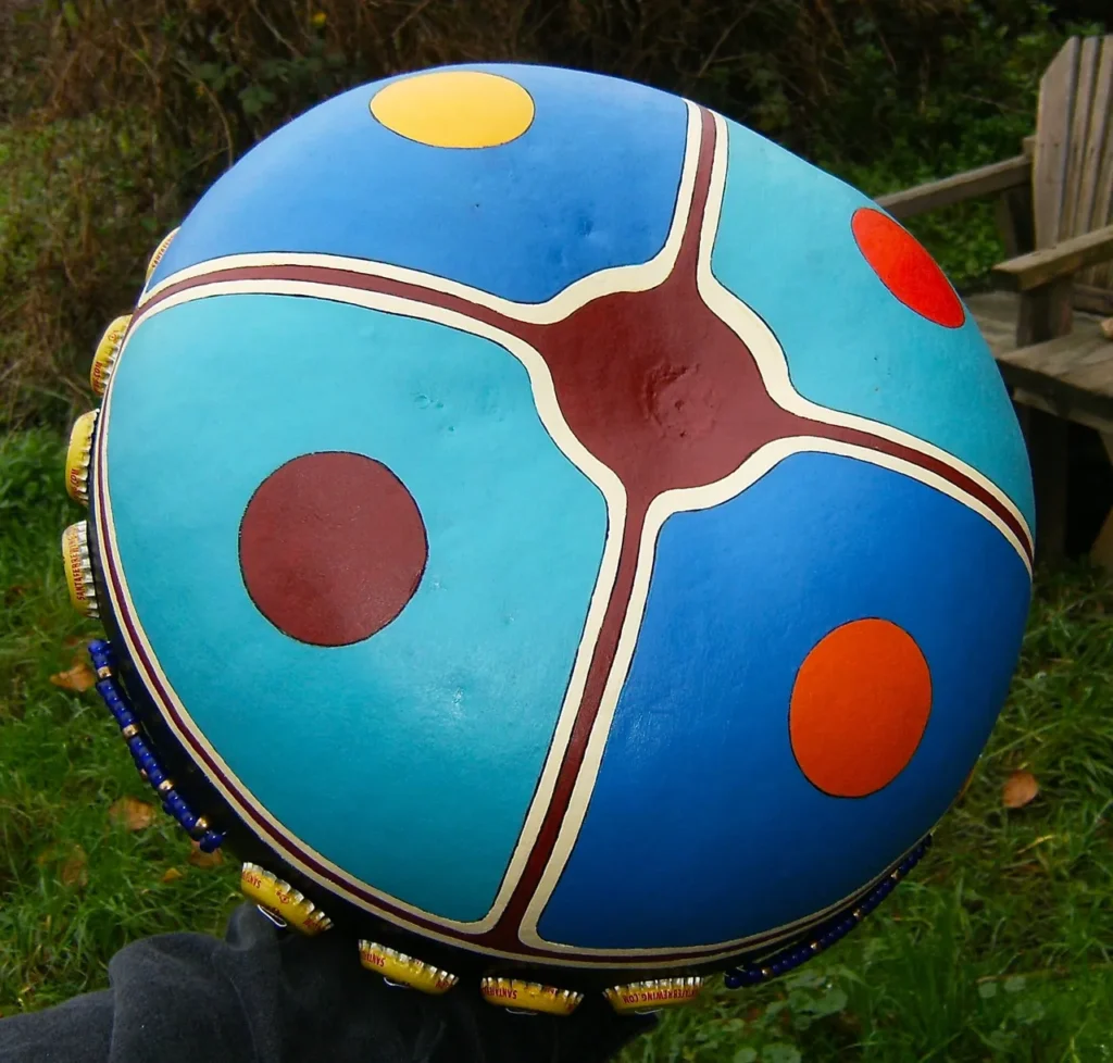 A person is holding a colorful drum called an ilimba.