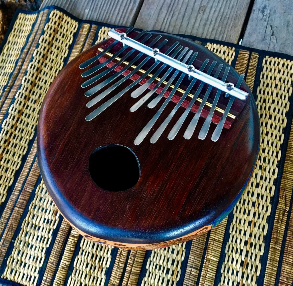 An African Music instrument called Ngoma, made of wood, sitting on a woven mat.