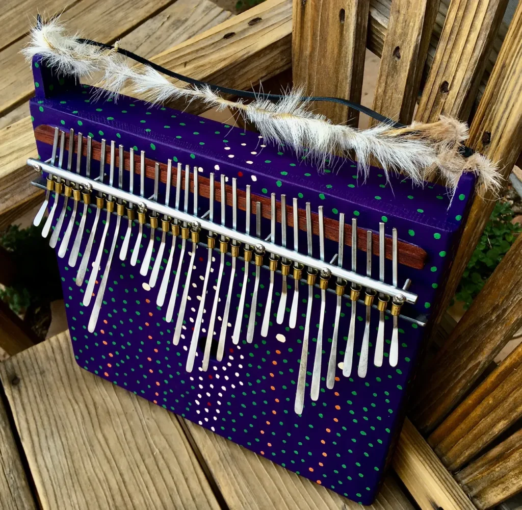 A purple musical instrument with feathers on it, called Kongoma.