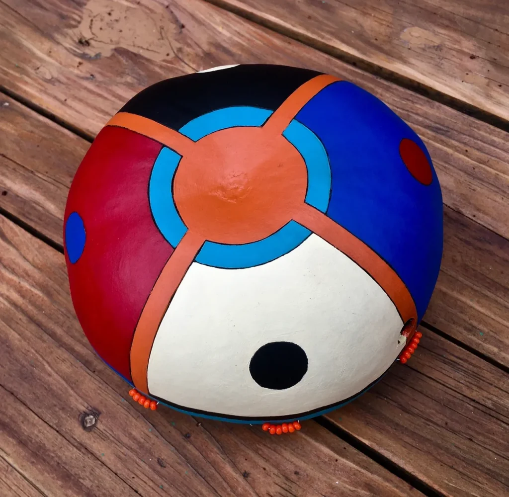 A colorful ball, reminiscent of the vibrant beats of Ngoma African Music, sitting on top of a wooden table.