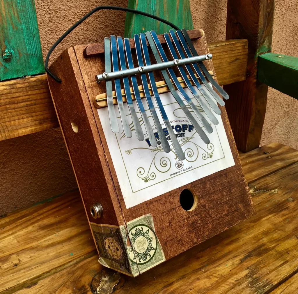 A lamellaphone is sitting on top of a wooden bench.