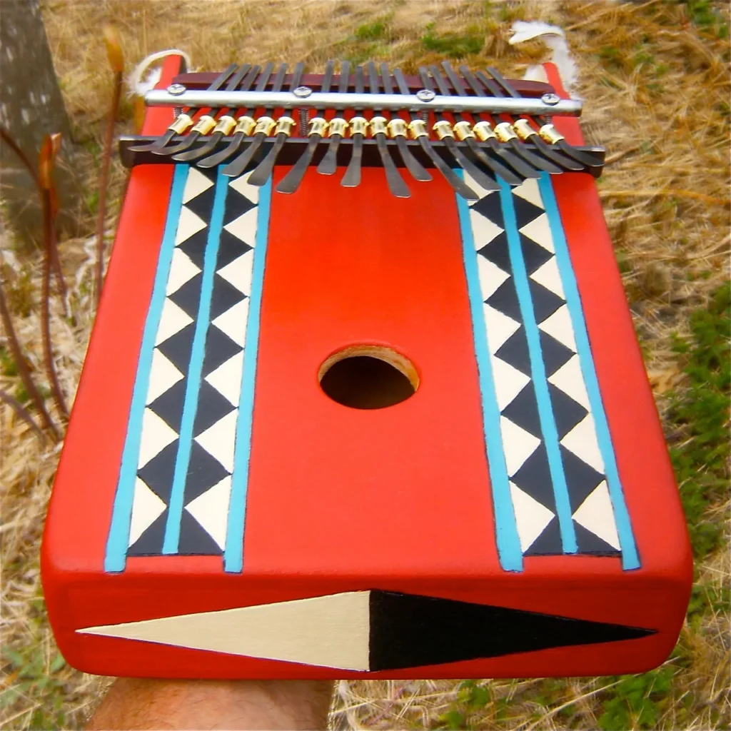 A person is holding a red Ngoma instrument.