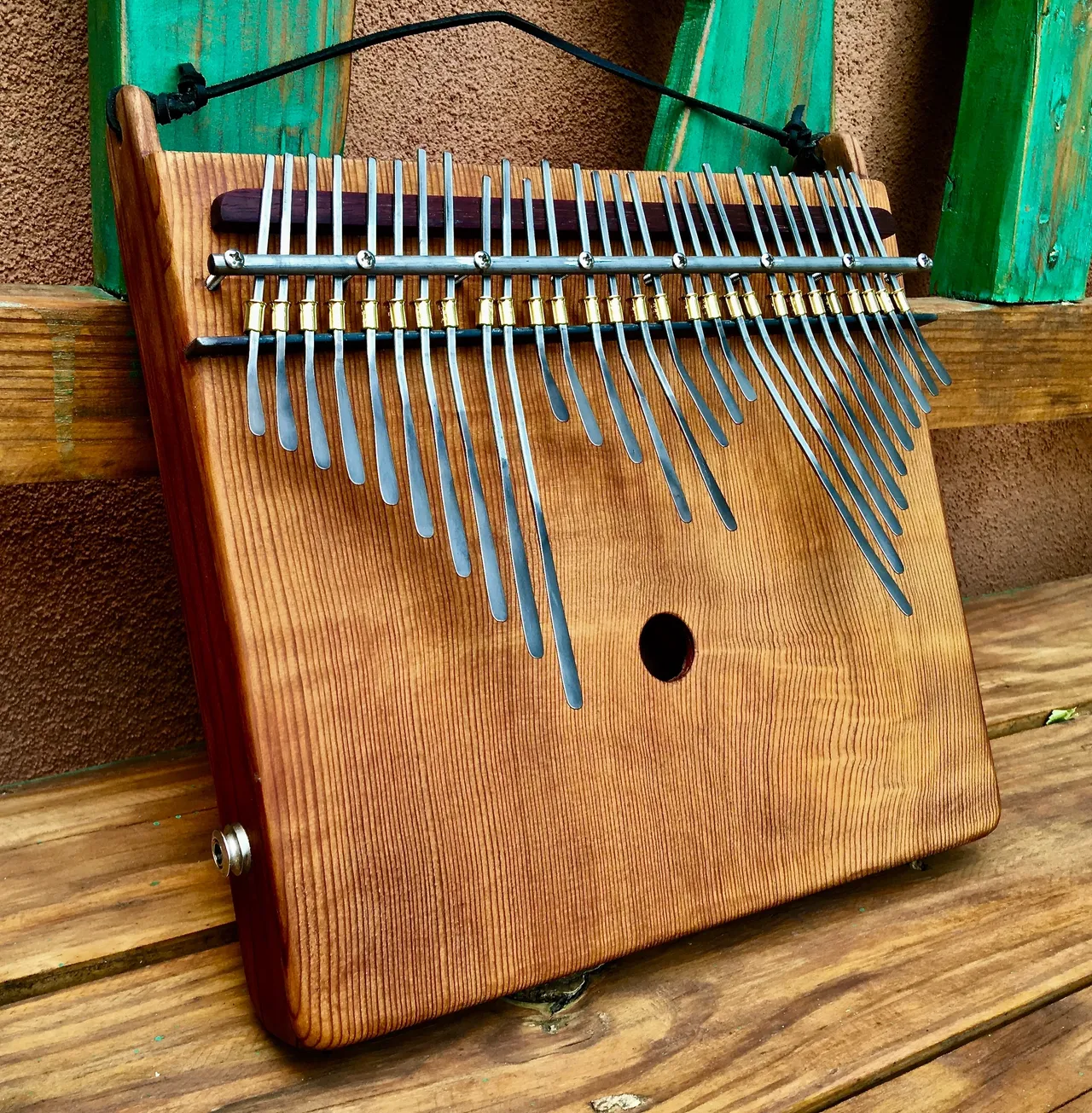 A wooden lamellaphone, resembling a xylophone, sitting on a wooden bench.