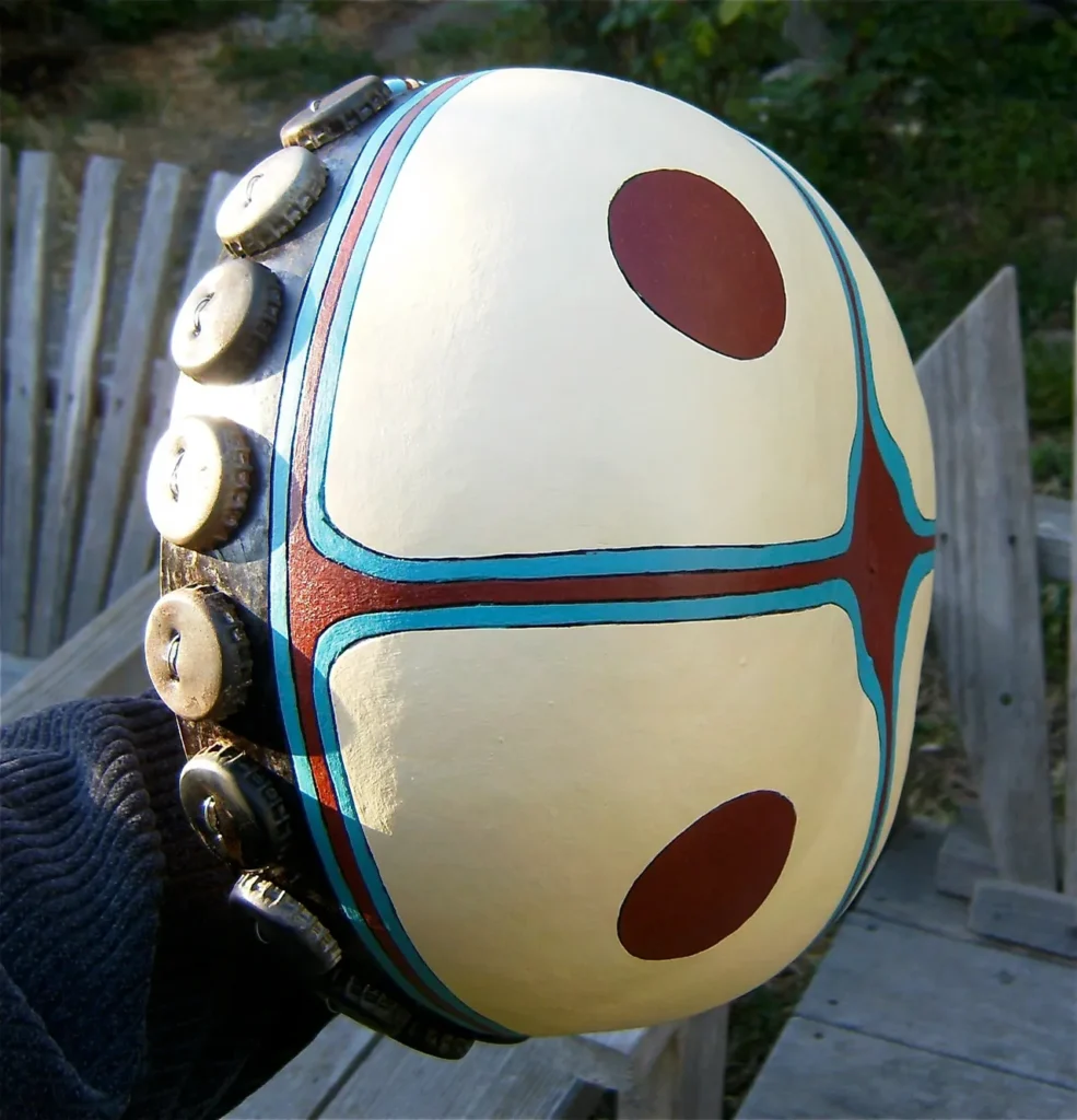 A person holding a Ngoma drum with buttons on it, creating enchanting African music.