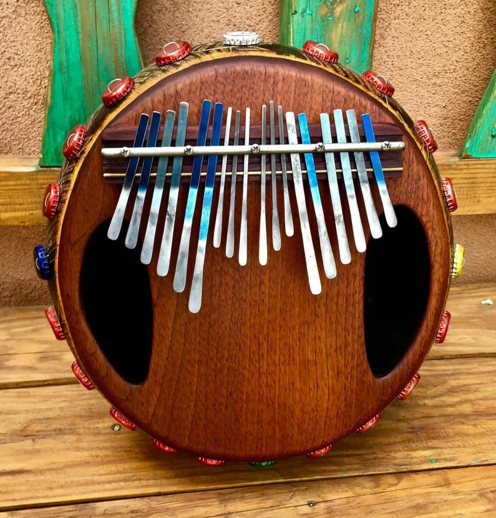 An Ilimba ukulele featuring intricate African harps carved onto its wooden body.