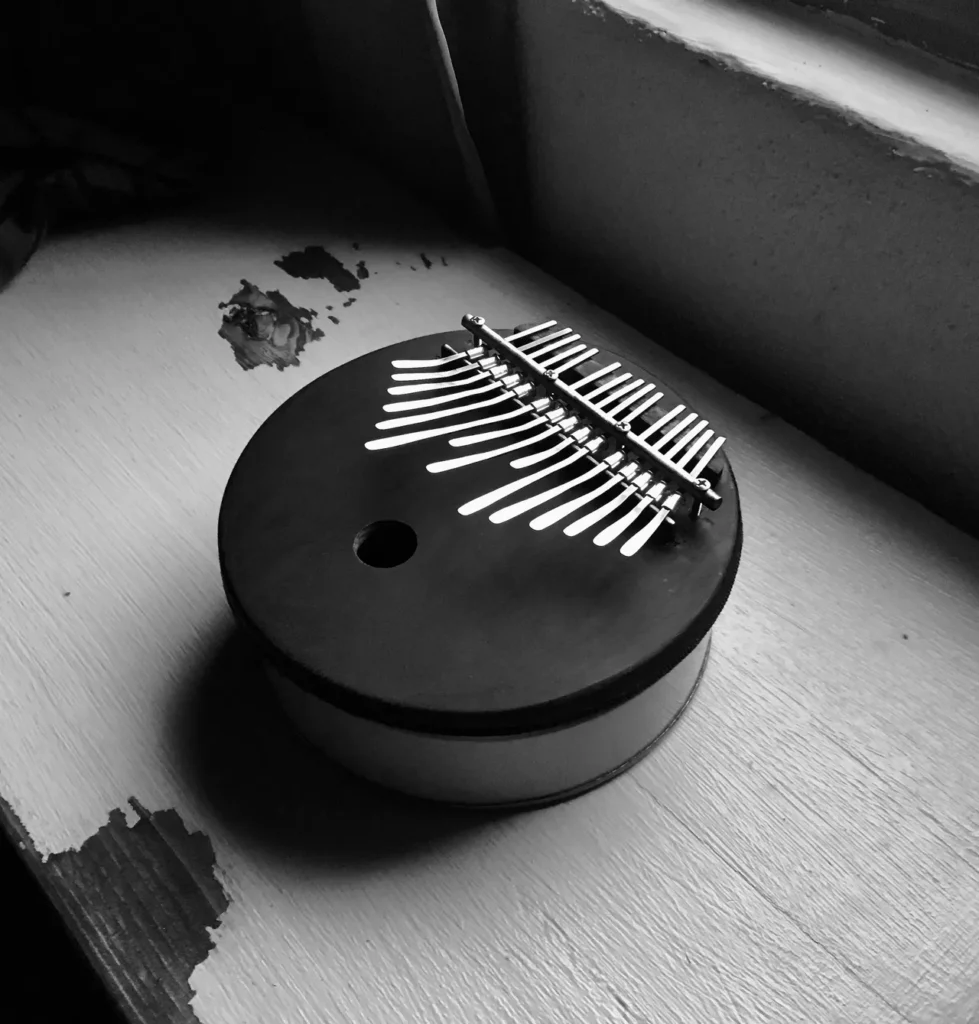 A black and white photo of a small box on a window sill, inspired by Ngoma, the rich tradition of African music.