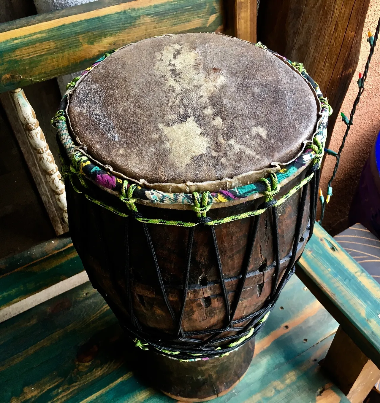 An Ilimba djembe sitting on a wooden bench.