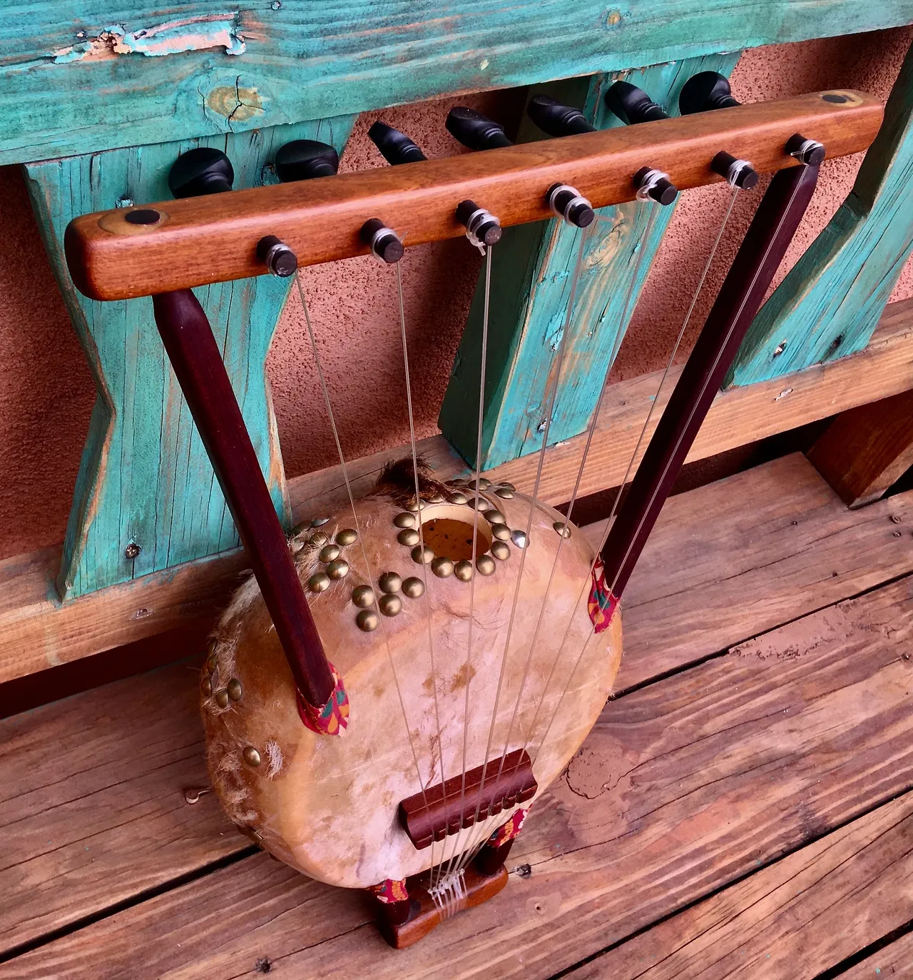 A wooden harp (Kalimba) sitting on a wooden bench.