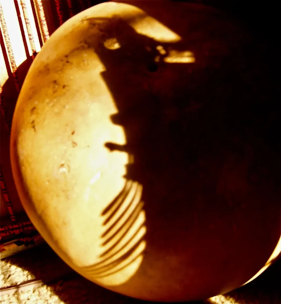 The silhouette of a pumpkin casts a haunting shadow on the wall.