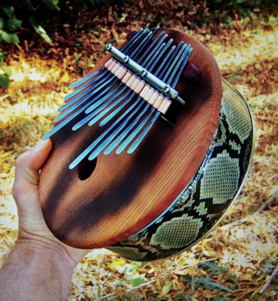 A person holding a wooden python ukulele, playing a lively Ngoma tune.