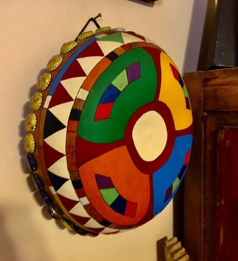 An Ngoma, a colorful drum, hanging on a wall in an African Music-themed room.