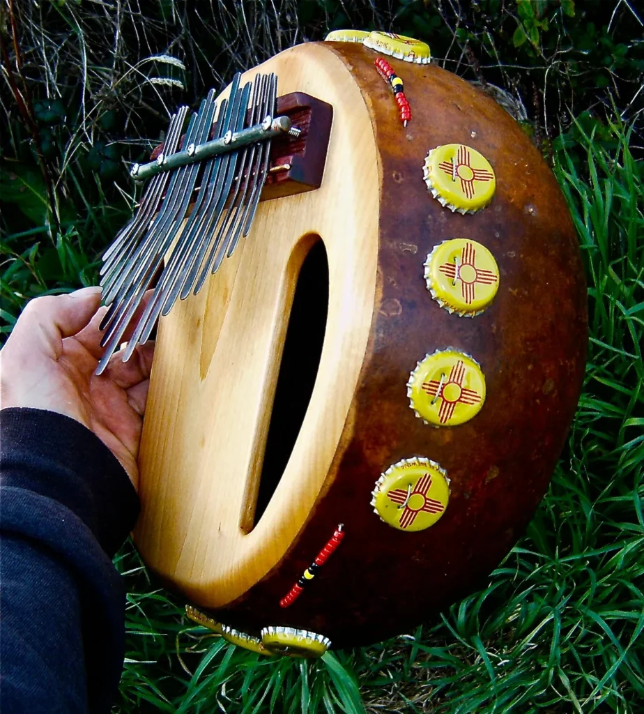 A person holding an Ilimba in the grass.