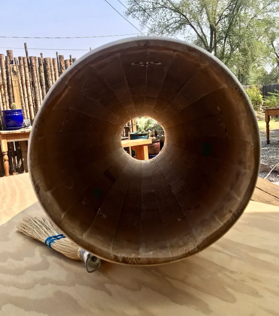 A large wooden Ilimba bowl sitting on a wooden table.