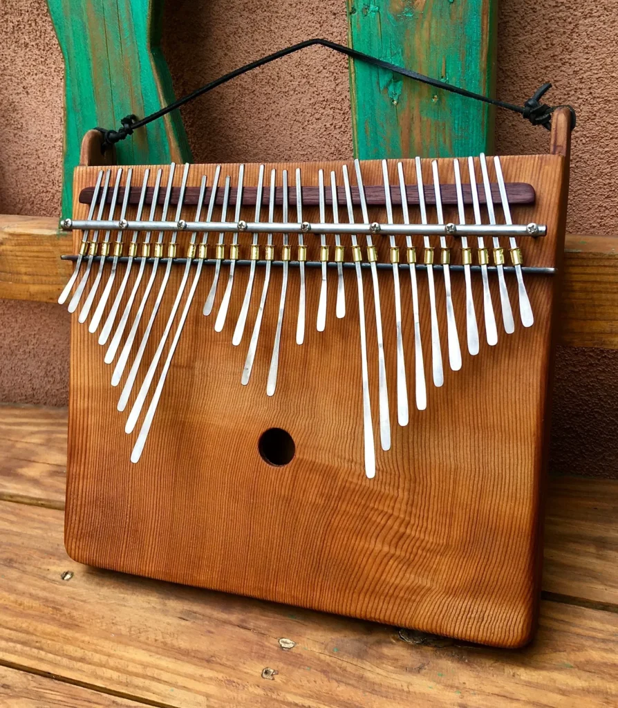 A wooden ukulele, also known as a gourd instrument, is sitting on a wooden bench.