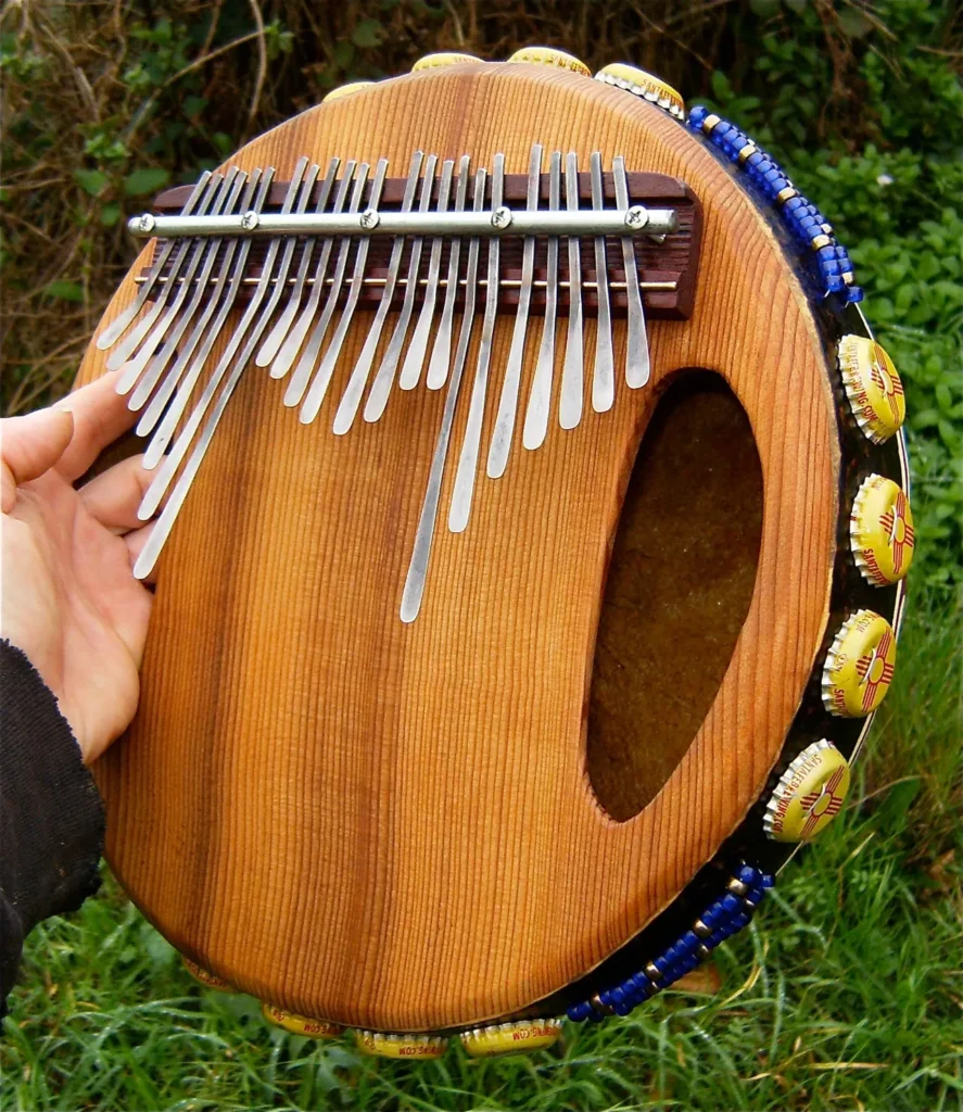 A person is holding an Ilimba, an African harp made of wood, in their hand.