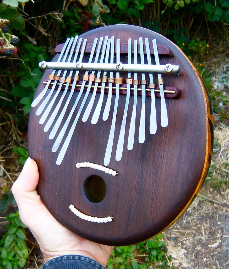 A person is holding a wooden Ngoma in their hand.