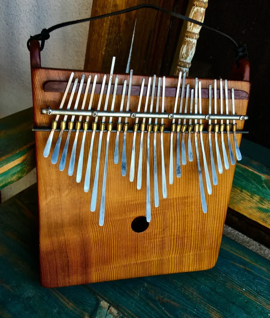 A wooden xylophone, also known as Marimbula, sitting on a wooden table.